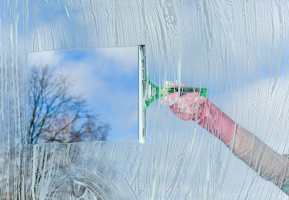 Early spring windows cleaning. Maid cleans window.